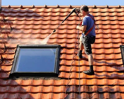 Démoussage et nettoyage de toiture en tuiles avec pulvérisation d’eau sur une maison individuelle en Seine-et-Marne