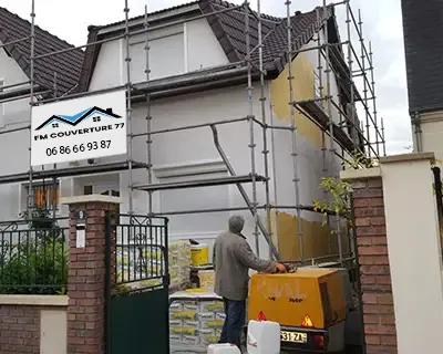 Travaux de ravalement de façade sur maison individuelle avec échafaudage et matériaux de chantier en Seine-et-Marne